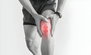 a man with knee pain holding his knee