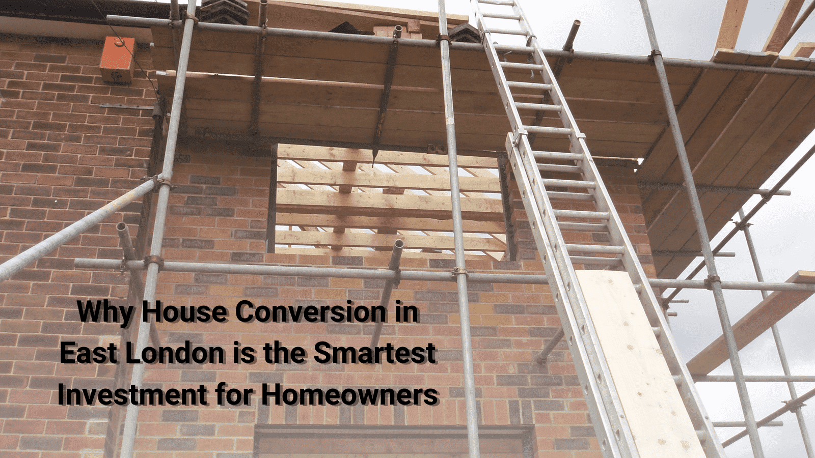 The image shows a construction scene where scaffolding and a ladder are set up against the exterior of a brick house. The building appears to be undergoing a conversion or renovation, as indicated by the exposed wood framework and construction materials visible. The text overlaid on the image reads, "Why House Conversion in East London is the Smartest Investment for Homeowners." The image likely illustrates the idea of property enhancement and increasing home value through conversion projects.